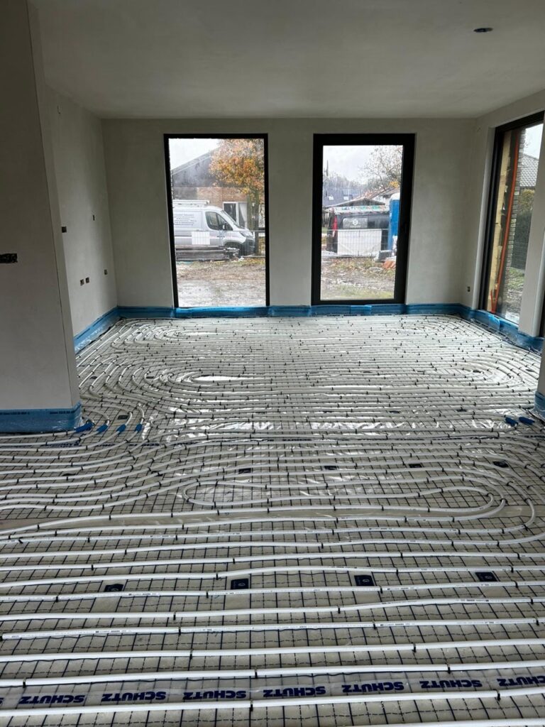 Vloerverwarming installatie met buizen op betonvloer in nieuwbouwwoning met grote ramen