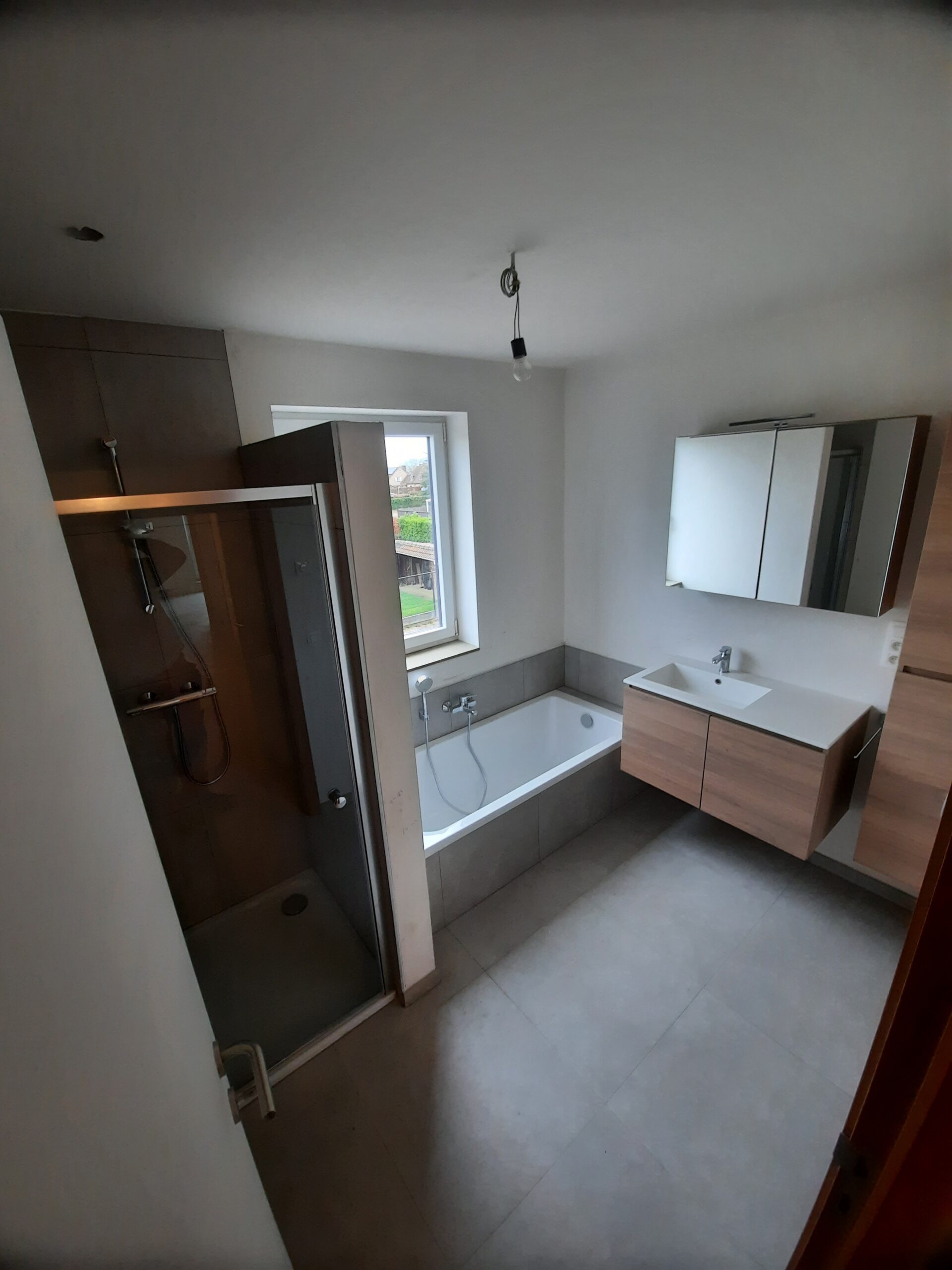 Moderne badkamer met douchecabine, badkuip, zwevende wastafel en spiegelkast in neutrale kleuren